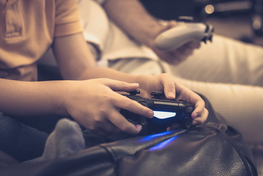 Close up of kid and his father playing video games.