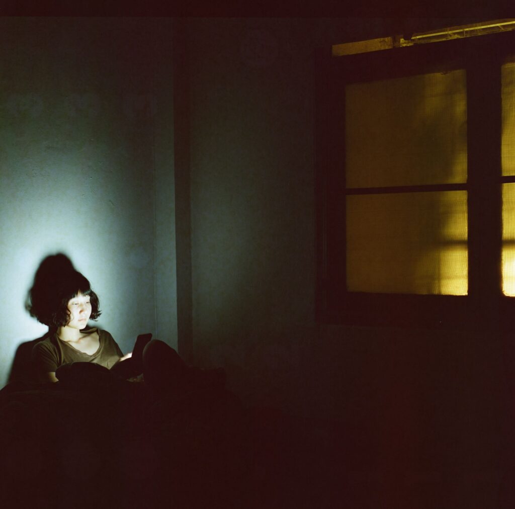 Woman using phone darkroom
