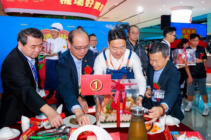 讓傳統辦桌文化在國門展開全新餐飲體驗，交通部長陳世凱換上圍裙親自上菜。（昇恆昌免稅商店提供）